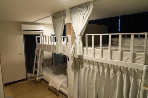 due letti a castello con tende bianche in una stanza di Greet Hostel & Cafe Samyan a Bangkok