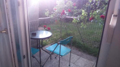 a patio with a table and two chairs and a window at Vila Ema Apartments and Rooms in Ljubljana