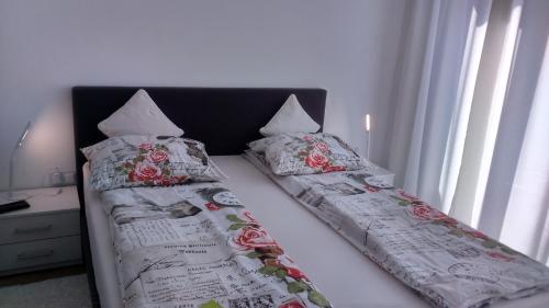 a bed with two pillows on top of it at Vila Ema Apartments and Rooms in Ljubljana