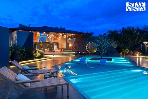 uma vila com piscina à noite em StayVista at Prana Zen House with Pool and BBQ em Nashik