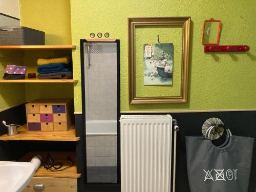 een badkamer met een witte radiator en een spiegel bij Chez Corinne in Valence