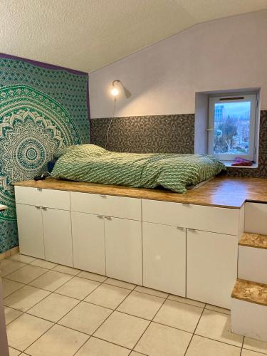 a bedroom with a bed on top of a counter at Chez Corinne in Valence