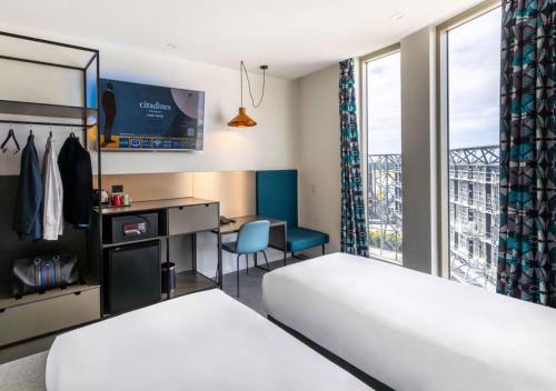 悉尼Citadines Connect Sydney Airport的一间有两张床、一张桌子和一扇窗户的酒店房间