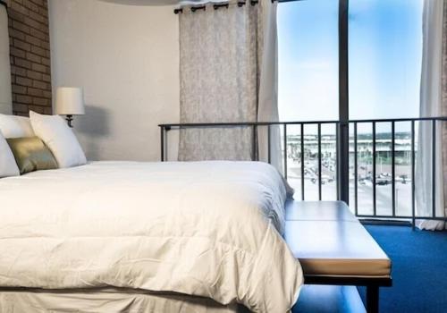 a bedroom with a large bed and a balcony at The Landmark Hotel in Laredo