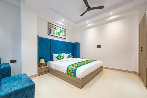 een slaapkamer met een kingsize bed en een blauw hoofdeinde bij Treebo Accent Park Hotel And Banquet in Noida