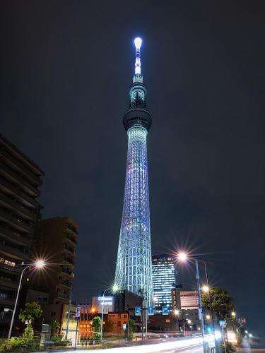 a tall tower lit up with blue lights at night at 桜の川50 東京晴空塔10分钟本所吾妻橋駅5分钟5人房丨 Tokyo skytree 10 mins Honjo Azumabashi 5 minutes5 people in Tokyo