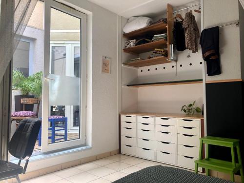 een kamer met een kast met een spiegel en een raam bij Chez Corinne in Valence