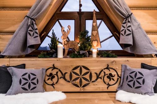 a room with a window with candles and a table with pillows at Pensjonat Orlik Mountain Resort&SPA in Bukowina Tatrzańska