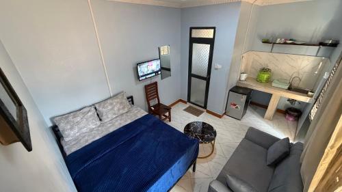 a living room with a blue bed and a couch at COMFORT HAVEN Studio in Ilemera