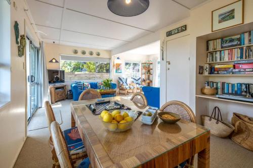 a kitchen with a table with a bowl of fruit on it at Seahorse Cottage - Stay Waiheke in Waiheke Island