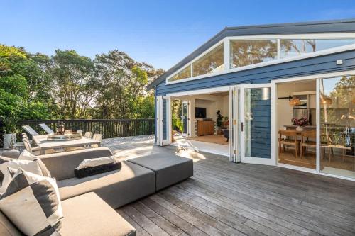 a living room with a couch and a patio at Skyview Onetangi - Stay Waiheke in Waiheke Island
