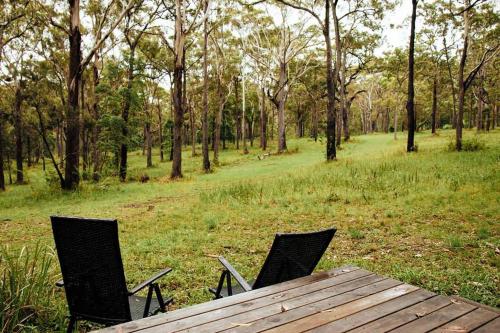 ArrawarraにあるSolitary Islands Farm 3 by Tiny Awayの野原の椅子2脚と木製テーブル