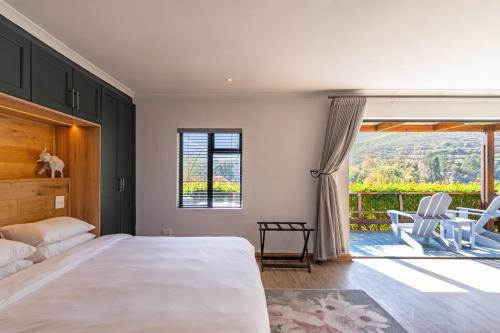a bedroom with a large bed and a large window at Mont Angelis in Stellenbosch