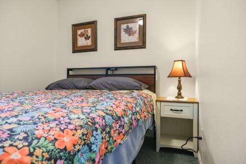 ein Schlafzimmer mit einem Bett und einem Nachttisch mit einer Lampe in der Unterkunft 3BR Home • Near Maverik Center & Valley Fair in West Valley City