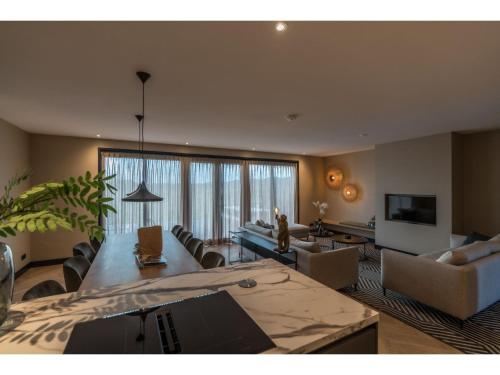 Modern villa in De Cocksdorp near the beach في دي كوكْسدوربْ: غرفة معيشة كبيرة مع أريكة وطاولة