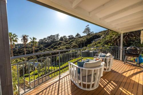 a balcony with chairs and a view of the mountains at Hibiscus Hideaway - Stay Waiheke in Palm Beach
