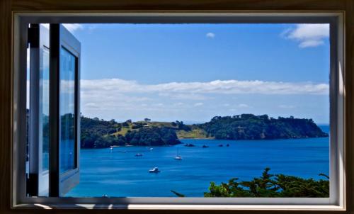 a window view of a bay with boats in the water at Viewpoint - Stay Waiheke in Onetangi