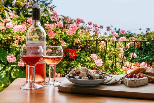 a glass of wine and a bowl of food on a table at Sunshine Cottage by the Sea - Stay Waiheke in Onetangi