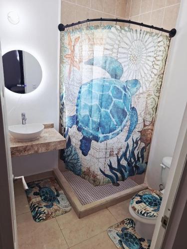 a bathroom with a shower with a turtle shower curtain at Vacation Home in Playa Del Carmen in Playa del Carmen