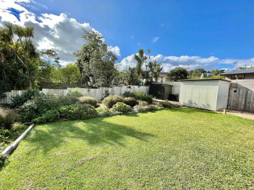 a backyard with a fence and a grass yard at Getaway Waiheke- Stay Waiheke in Oneroa