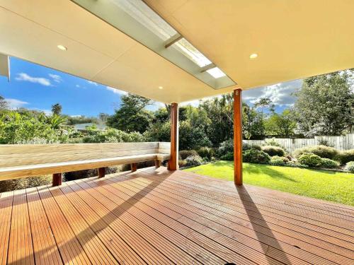 an empty porch with a bench on a wooden deck at Getaway Waiheke- Stay Waiheke in Oneroa