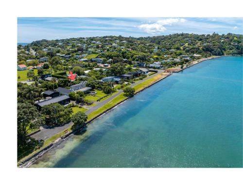 an aerial view of a beach with houses and the water at Alhambra - Stay Waiheke in Oneroa