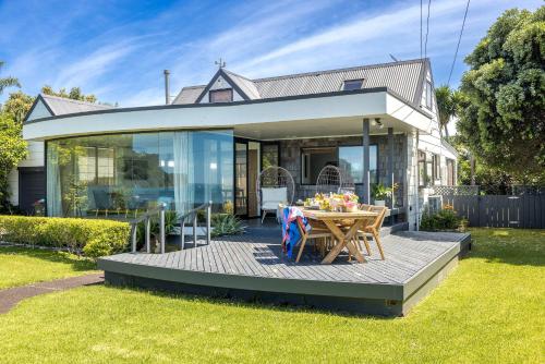 a house with a table in the front yard at Alhambra - Stay Waiheke in Oneroa