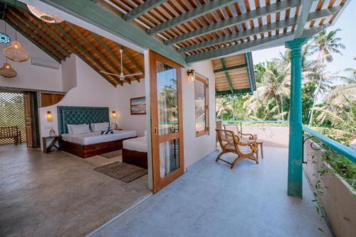 an outdoor patio with a bed and a couch at Sithagi River Front Villa Weligama in Weligama