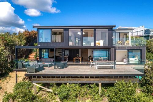 una casa en la playa con terraza en Moana Retreat - Stay Waiheke, en Putaki Bay