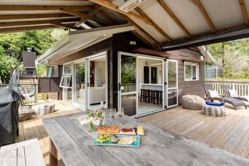 un patio con una mesa con comida. en Miro Magic - Stay Waiheke, en Palm Beach