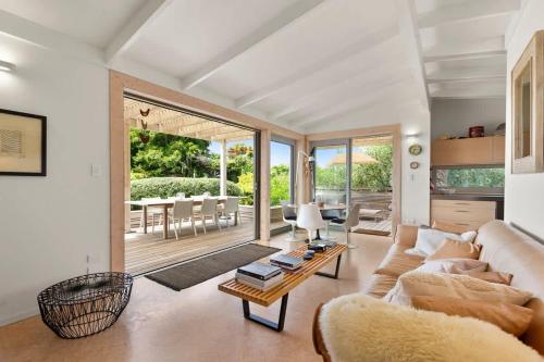 een woonkamer met een bank en een tafel bij Palm Views - Stay Waiheke in Palm Beach