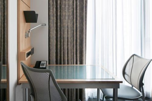 a glass table and chairs in a room with a window at Club Quarters Hotel World Trade Center, New York in New York