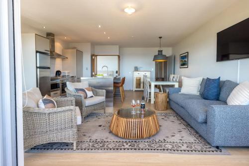 a living room with a couch and a table at The Sands - Apartment 5 - Stay Waiheke in Onetangi