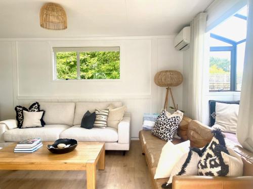 a living room with a couch and a table at Bach 14 - Stay Waiheke in Blackpool