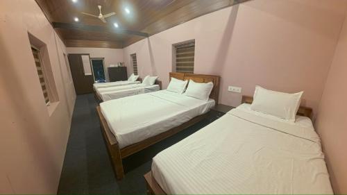 a room with three beds in a room at Bucolic Resort in Panamaram