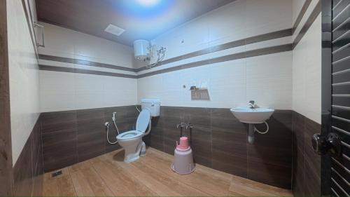 a bathroom with a toilet and a sink at Bucolic Resort in Panamaram