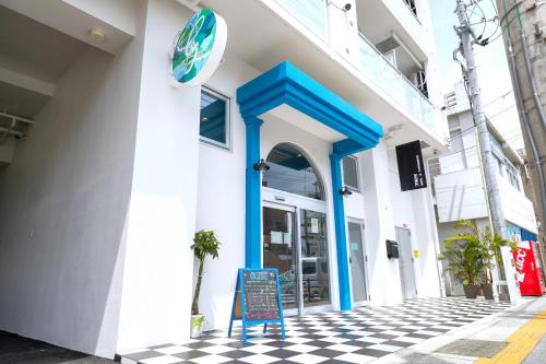 a store front with blue columns and a sign in front at Glory island okinawa SOBE in Naha