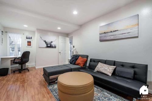 a living room with a black couch and a stool at Cozy Charming Richmond 1BR Retreat in San Francisco