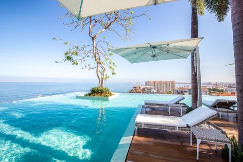 a swimming pool with a view of the ocean at Pier 57 Romantic Zone Luxury Condo 209 in Puerto Vallarta