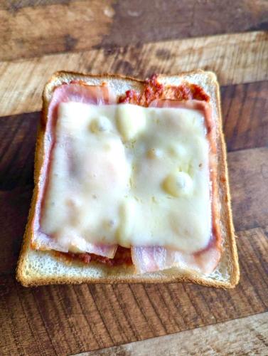 un trozo de pan con queso y salsa. en 遊子川ゲストハウス コッコロん, en Seiyo