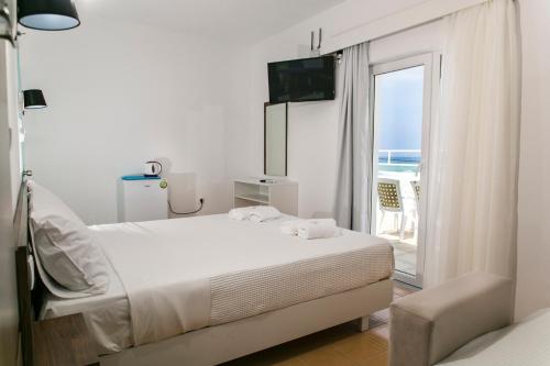 a bedroom with a bed and a view of the ocean at Kissamia Rooms - Next to Night Clubs in Kissamos