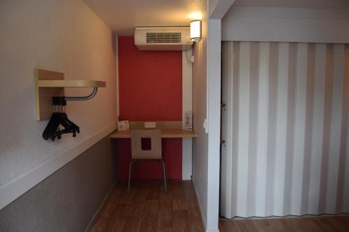 a hallway with a room with a desk and a heater at Premiere Classe Creil - Villers Saint Paul in Villers-Saint-Paul
