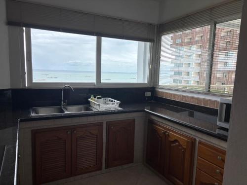 a kitchen with a sink and two windows at View Talay 6 Pattaya Beach by Anatolia Condo Suite in Pattaya Central