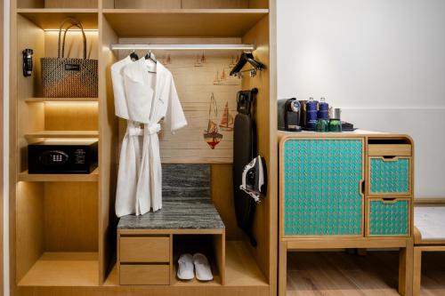 奥南海滩Grand Mercure Krabi Ao Nang的房间里有衣柜（里面放着浴袍）和水槽。