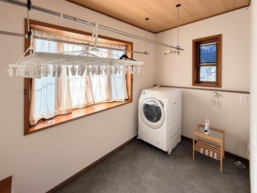 a laundry room with a washing machine and a window at 新規オープン 越後湯沢駅徒歩4分 スキー場アクセス抜群 最大14名 Snowtopia in Yuzawa