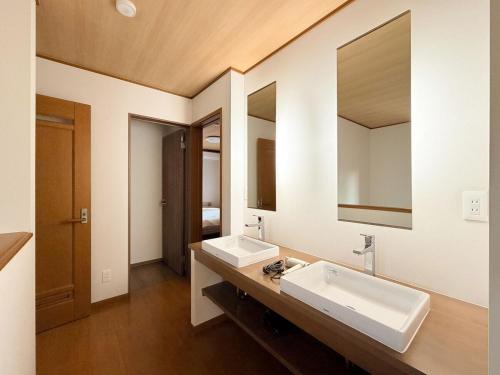a bathroom with two sinks and a large mirror at 新規オープン 越後湯沢駅徒歩4分 スキー場アクセス抜群 最大14名 Snowtopia in Yuzawa