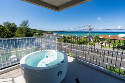 a bath tub on a balcony with a view of the ocean at Emerald Ocean Villa in Onna
