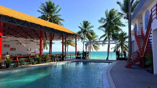 a swimming pool with a view of the ocean at Umi Resort 菩提有米 in Sihanoukville