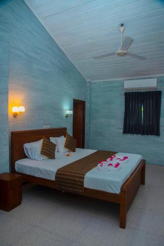 a bedroom with a bed with flowers on it at Lucky Rest in Beruwala