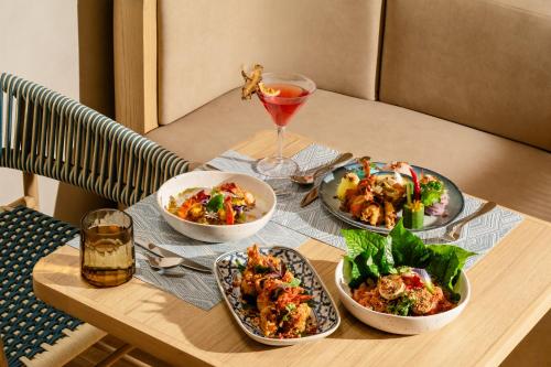 奥南海滩Grand Mercure Krabi Ao Nang的一张桌子上摆放着四道菜和一杯饮料。